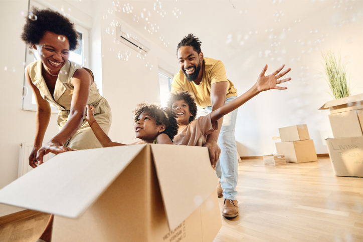 family moving with kids riding along in a moving box